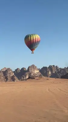 a hot air balloon flying over the desert at Moon Camp in Al Jafr