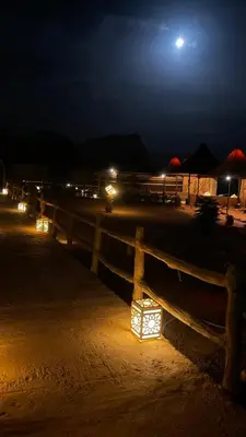 a wooden fence with lights on it at night at Moon Camp in Al Jafr