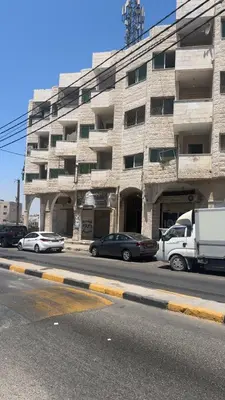 a large stone building with cars parked in front of it at Studio in the Heart of Irbid in Irbid