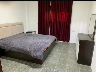 a bedroom with a bed and a dresser and red curtains at Enjoy moment chalet