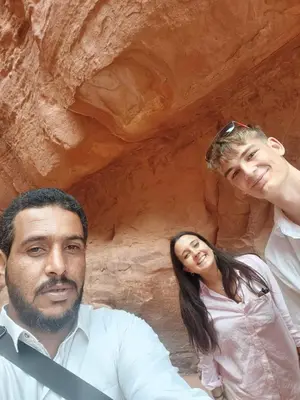 a man and a woman standing in front of a cave at Adventure Nights Camp in Wadi Rum