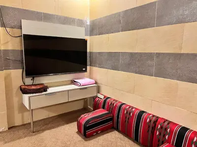 a room with a tv on a wall at الفاخر للشقق الفندقيه in Al Mafraq