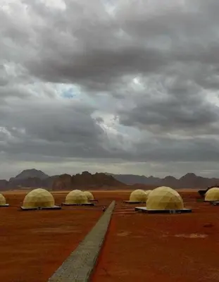 a group of domes in the desert under a cloudy sky at Wadi Rum Luxurious Camp View in Wadi Rum