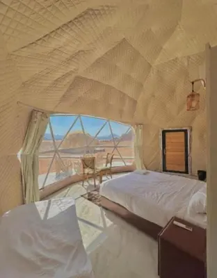 a bedroom with a bed and a view of the desert at Wadi Rum Luxurious Camp View in Wadi Rum