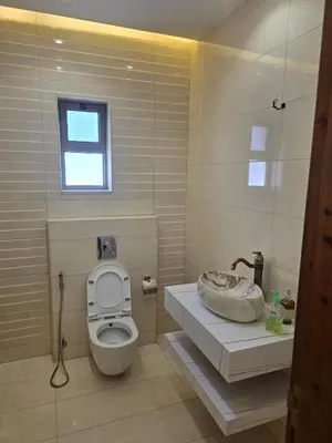 a bathroom with a toilet and a sink and a window at Le Jardin in Madaba