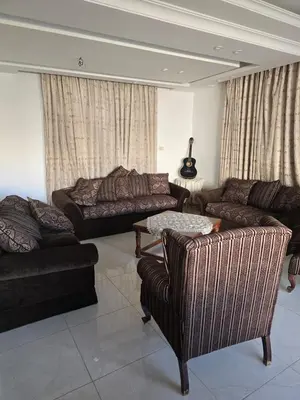 a living room with two couches and a table at Le Jardin in Madaba