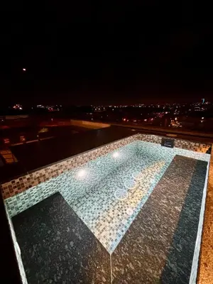 a swimming pool on top of a building at night at Luxury Roof-top in Amman