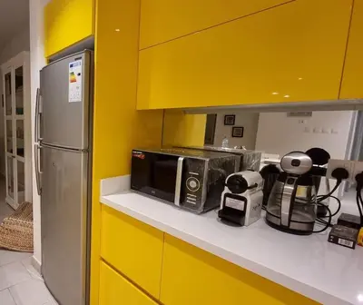 a kitchen with a counter with a microwave and a refrigerator at Island Apartment in Aqaba