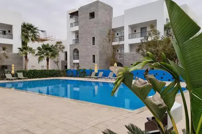 a swimming pool in front of a building at Island Apartment in Aqaba