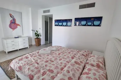 a bedroom with a bed and a dresser at Island Apartment in Aqaba