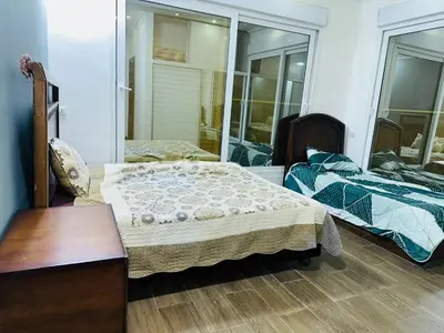a bedroom with two beds and a mirror at The Royal Chalet in Ath Thukhaynāt