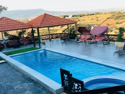 a large swimming pool with a view of the mountains at The Royal Chalet in Ath Thukhaynāt