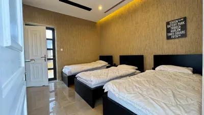 a room with three beds in a room at Giving City in Amman