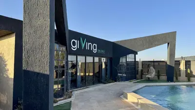 a building with a swimming pool in front of it at Giving City in Amman