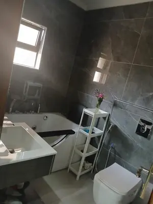 a bathroom with a toilet and a sink and a bath tub at Five-star hotel apartment in Amman