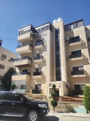a black suv parked in front of a building at Amman in Amman