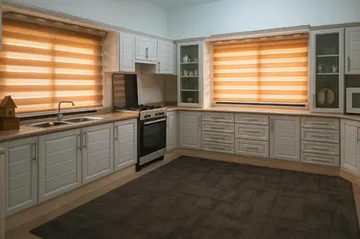 a large kitchen with white cabinets and a sink at الخير شقق مفروشه in Al Jafr