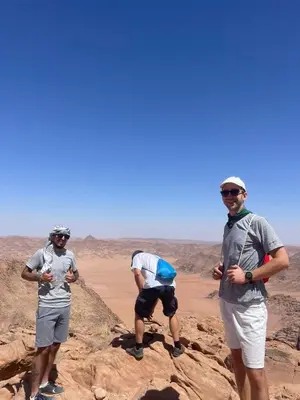three men standing on rocks in the desert at Wahj Ram camp in Aqaba