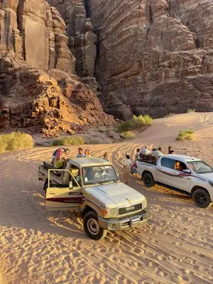 a group of people and vehicles in the desert at Wahj Ram camp in Aqaba