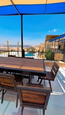 a picnic table and chairs on a roof with a view at Al Eman Oasis Farm in Jal‘ad