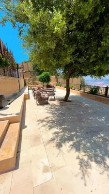 a group of benches sitting under a tree at Al Eman Oasis Farm in Jal‘ad