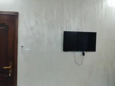 a flat screen tv hanging on a wall at Ayla Furnished Apartments in Aqaba