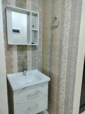 a bathroom with a white sink and a mirror at Ayla Furnished Apartments in Aqaba