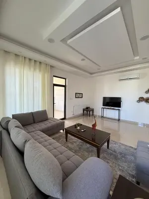 a living room with a couch and a table at Dabouq 3BR condo in Amman