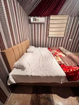 a bed in a room with a wall at Layla Wadi Rum in Disah