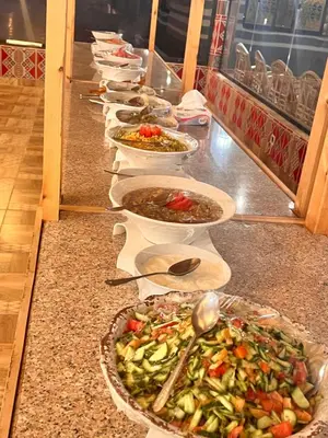 a buffet line of bowls of food on a counter at Layla Wadi Rum in Disah