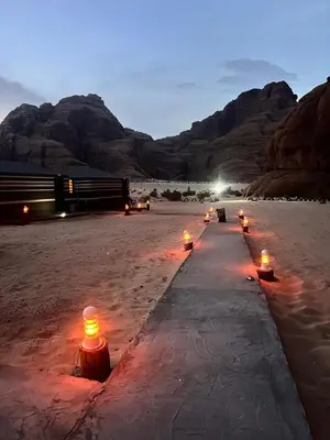 a row of candles in the desert with mountains in the background at Layla Wadi Rum in Disah