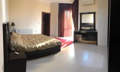 a bedroom with a bed and a dresser and a mirror at Apartment in the heart of Amman in Amman