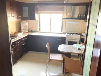 a small kitchen with a table and chairs and a window at Apartment in the heart of Amman in Amman