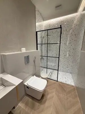 a white bathroom with a toilet and a window at amazing rooftop-studio at abdoun 702 in Amman