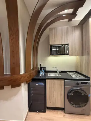 a kitchen with a stove and a sink and a microwave at amazing rooftop-studio at abdoun 702 in Amman