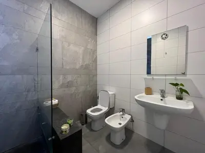 a bathroom with a toilet and a sink and a mirror at Newly refurbished 2-bedroom flat in a compound in Amman