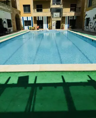 a large swimming pool with the shadows of a building at Swemeh hills resort in Sowayma