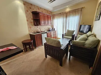 a living room with a table and chairs and a kitchen at Swemeh hills resort in Sowayma