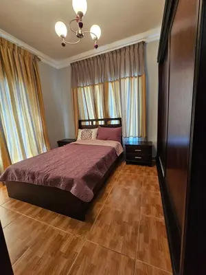 a bedroom with a large bed and wooden floors at Swemeh hills resort in Sowayma