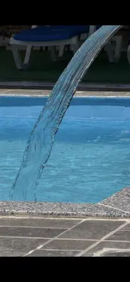 a swimming pool with a ramp in front of the water at شاليهات تلال اشتفينا in Ajloun