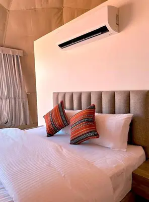 a bed with two pillows on top of it at Terra Nova Camp in Wadi Rum
