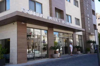 a woman is standing outside of a hotel at Golden Suites Hotel in Amman