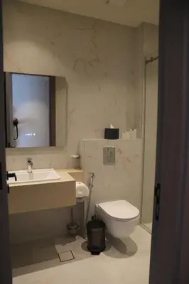a bathroom with a toilet and a sink and a mirror at Golden Suites Hotel in Amman