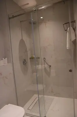 a shower with a glass door in a bathroom at Golden Suites Hotel in Amman