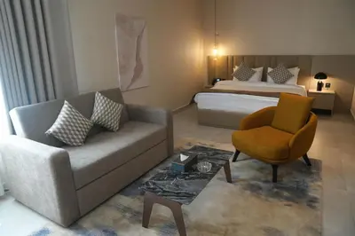 a living room with a bed and a couch and a chair at Golden Suites Hotel in Amman