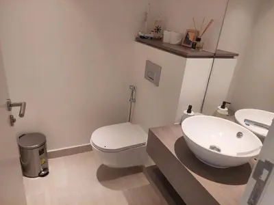 a bathroom with a white toilet and a sink at Brand new modern apartment in Ayla Golf residence in Aqaba