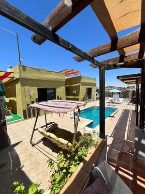 a patio with a table and a swimming pool at شاليه بانا جرش in Jerash