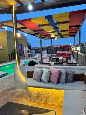a bench with pillows on a patio with a pool at شاليه بانا جرش in Jerash