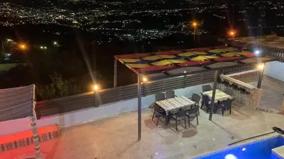 a patio with a table and chairs next to a pool at شاليه بانا جرش in Jerash