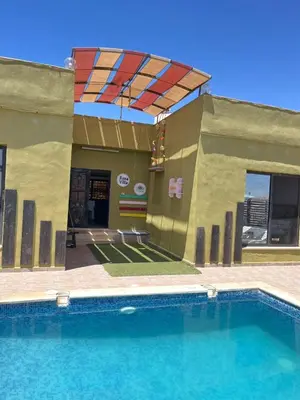 a building with a swimming pool and an umbrella at شاليه بانا جرش jerash